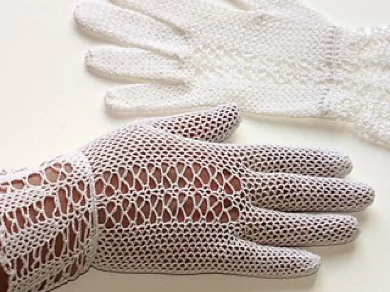 Detailed white crochet lace gloves with ornate pattern