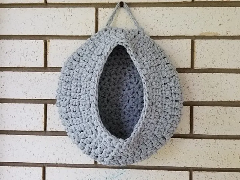 Chunky crochet hanging basket holding household items