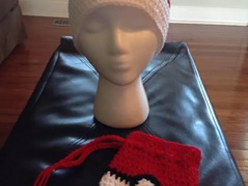 Child wearing red and white crochet Pokeball beanie
