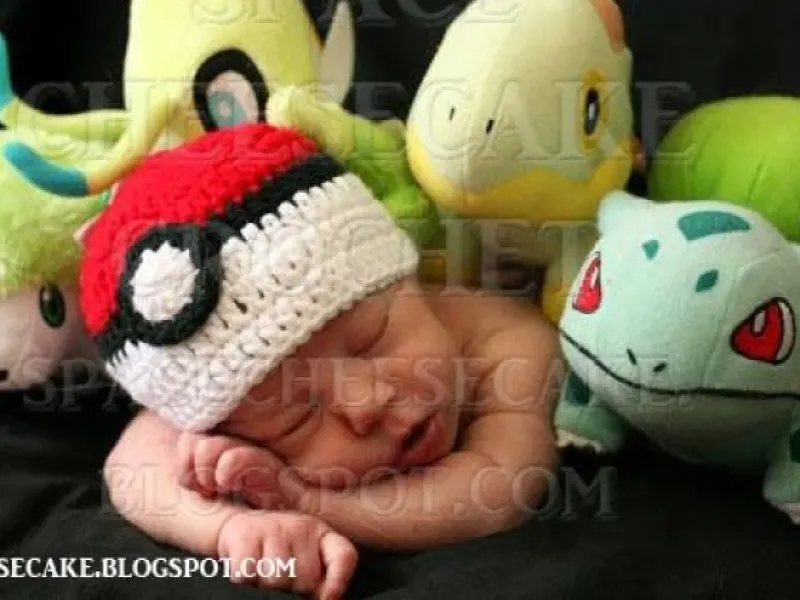 Newborn wearing small red and white crochet Pokeball hat