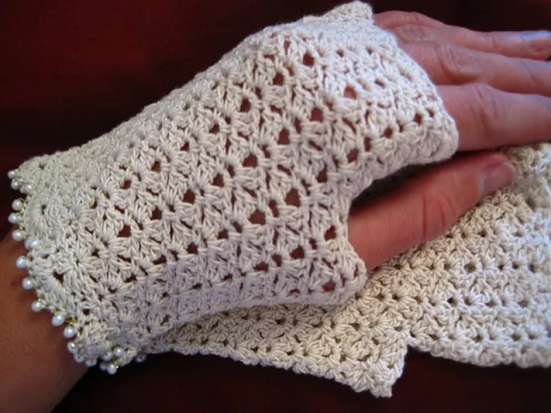 Small white lace crochet fingerless mitts on a hand