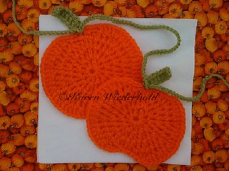 Crochet pumpkin garland in orange with green leaves