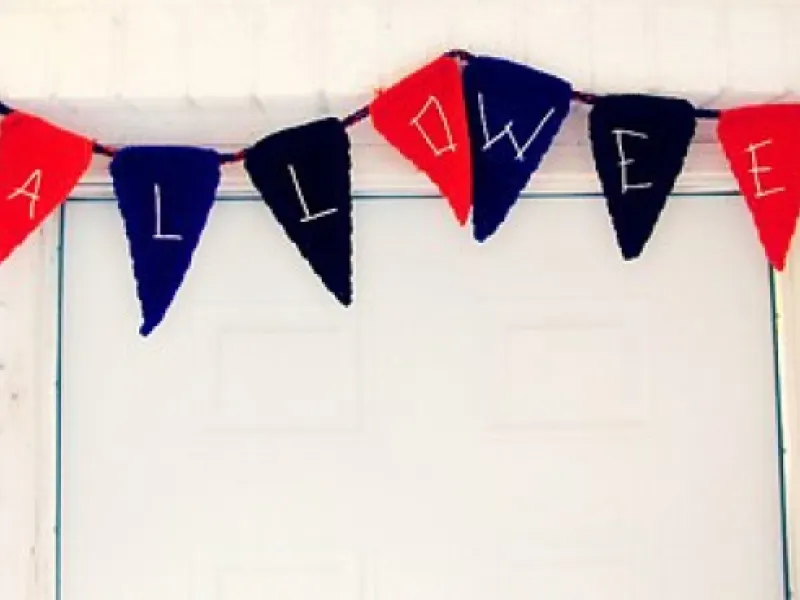 Crochet holiday bunting in seasonal colors hanging on a wall