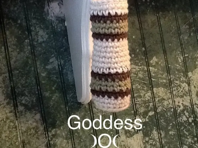 Tall cylinder-shaped crochet basket hanging on a wall
